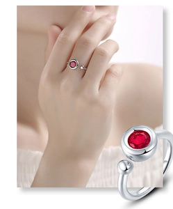 Macro detail of adjustable silver ring with vibrant red gemstone and bubble design