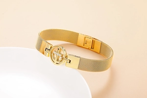 Gros plan du bracelet doré en acier inoxydable avec pendentif ancre serti de zircons