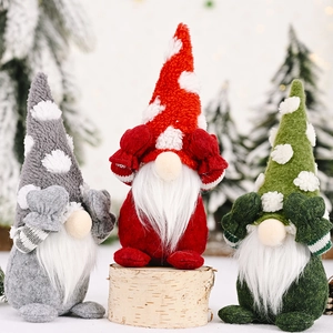 Three Christmas gnomes in grey, red, and green hats posing on a wooden block with snow