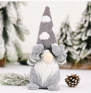 Close-up of a grey Christmas gnome plush with white polka dot hat and long beard