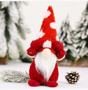 Detailed close-up of a Christmas gnome doll with a red hat covering its eyes in a snowy scene