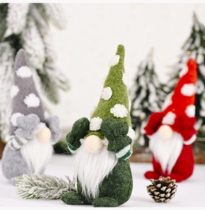 Three Christmas gnomes with long white beards in red, green, and grey felt hats
