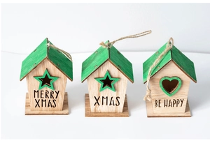 Three wooden Christmas house ornaments with green roofs and hanging ropes on white background