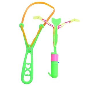 Detail of LED slingshot flying toy with green handle, yellow band and glowing pink blades
