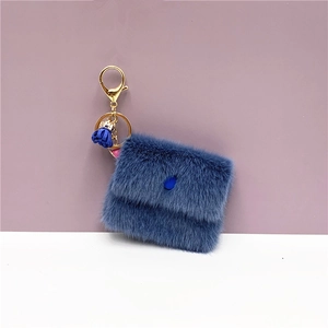 Close-up of a blue plush mini coin purse keychain with gold metal ring and tassel