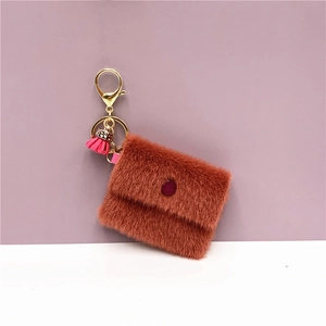 Detail showing plush mini coin purse with pink tassel and gold metal keychain clip