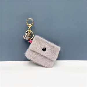 Detail of grey plush coin purse keychain with golden metal clasp and pink ribbon accent
