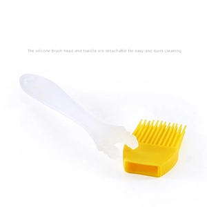 Yellow silicone basting oil brush with translucent white handle on white background