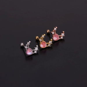 Détail de boucles d'oreilles couronne en argent, or et or rose avec des cœurs roses
