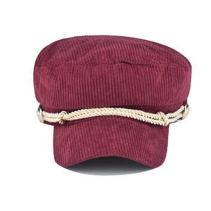 Close-up of burgundy corduroy newsboy hat with beige braided rope and metal side button