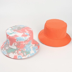 Detailed view of tie-dye and orange reversible cotton bucket hats for sun protection