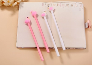 Creative flamingo gel pens in pink and white colors lying on an open notebook
