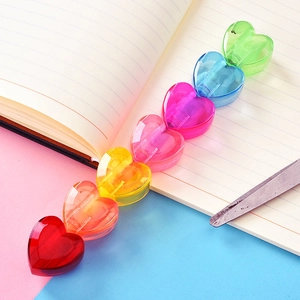 Detail of colorful transparent heart-shaped stackable highlighter pen components on a desk