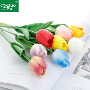 Close-up of realistic multi-color faux tulips with natural PU texture on an open magazine