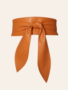 Detail of orange-brown faux leather obi belt with soft texture and bow tie styling