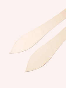 Close-up of cream leather belt detailing with fine stitching and pointed tip finish
