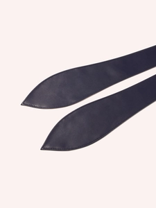 Detail of soft black leather belt showing fine texture and leaf-shaped pointed ends
