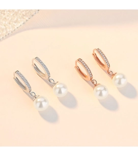 Detailed close-up of 925 sterling silver hoop earrings with pearl charms and pavé zircons