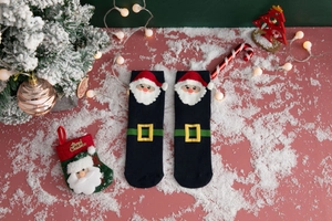 Detailed knit of Christmas socks with 3D Santa Claus pattern on a festive blue background