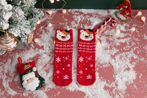 Detail view of festive red Christmas socks with cartoon bear and snowflake patterns
