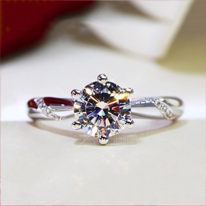 Macro detail of six-prong round cut sparkling diamond ring with micro-pave silver band