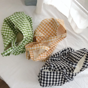 Plaid canvas tote bags in green orange and black displayed on white fabric background