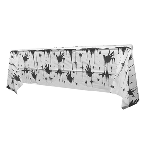Close-up of Halloween table cover featuring realistic black bloody handprints and droplets