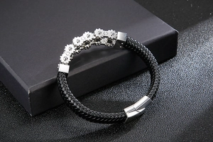Detail showing woven leather band with stainless steel gears on a jewelry box edge