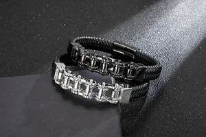 Close-up of woven leather bracelets with stainless steel gear chain details in black and silver