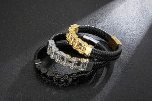 Detailed close-up of woven leather bracelets with gold, silver, and black metal chains