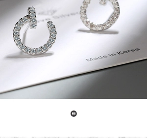Macro detail of silver C-shaped stud earrings with micro-pave white cubic zirconia crystals