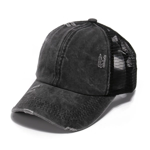 Detail of distressed washed denim baseball cap with ponytail opening and mesh back