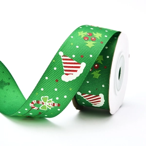Close-up of green Christmas grosgrain ribbon with festive candy cane and holly patterns