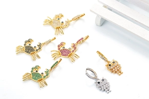 Detailed macro shot of crab and owl earrings inlaid with colorful zircon and rhinestones