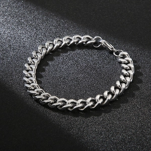 Macro shot of silver Cuban chain bracelet with polished stainless steel links on dark surface