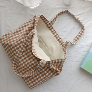 Close-up of brown plaid cotton tote bag showing inner pocket and beige canvas lining