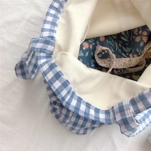 Detail of blue gingham tote bag with floral lining and drawstring closure design