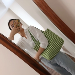 Detail view of large green and white checkered canvas tote bag with wide shoulder strap