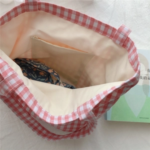 Detail of pink gingham canvas tote bag interior showing inner zipper pocket and lining