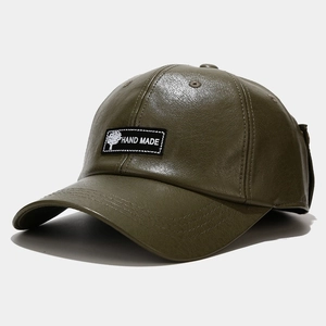 Macro shot of olive green PU leather baseball cap with handmade tree patch detail