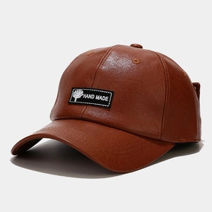 Detailed view of dark brown PU leather baseball cap with vintage hand-made label