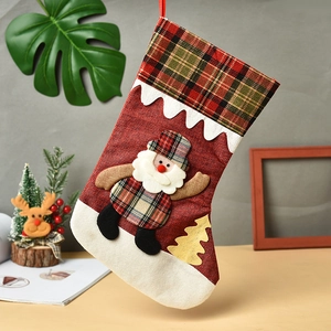 Classic red Christmas stocking with green plaid trim and Santa Claus burlap gift bag decor