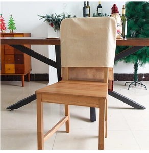 Detail of beige linen Christmas chair cover featuring festive embroidery in a home setting
