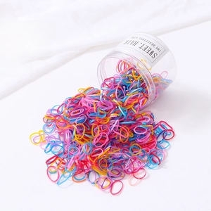 Vue macro de 800 élastiques à cheveux jetables colorés dans un bocal rond transparent