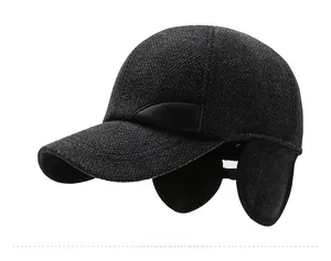 Detail of dark grey winter baseball cap with ear flaps and embossed sports leather label