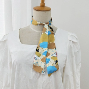 Long printed silk scarf with colorful geometric patterns tied on handle for handbag decoration