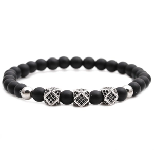 Nahaufnahme von 6mm matten schwarzen Steinperlen Armband mit silbernen Kronen auf weißem Grund