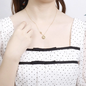 Collier pendentif tournesol en acier doré élégamment porté par un mannequin féminin