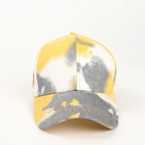 Détail d'une casquette de baseball en coton tie-dye jaune et blanc avec visière courbée