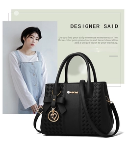 Close-up of black PU leather handbag featuring woven texture and metallic charm